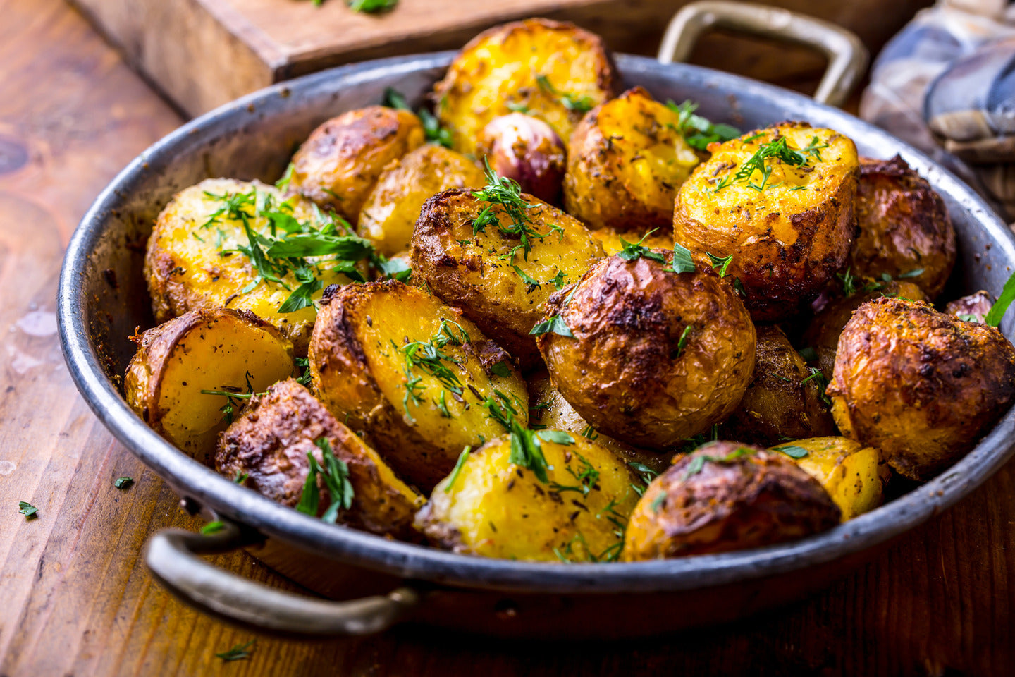 Pan of golden roasted baby potatoes tossed with fresh herbs