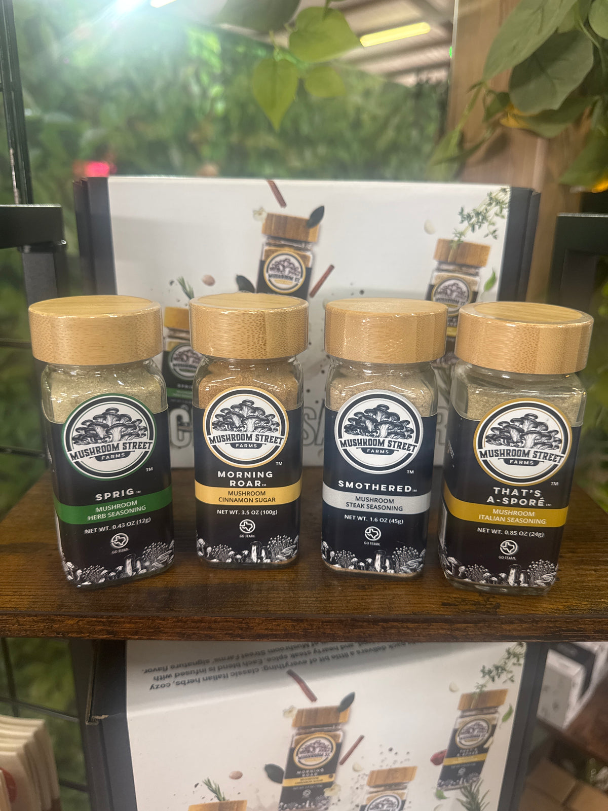 Four Mushroom Street Farms seasoning jars on a shelf: Sprig, Morning Roar, Smothered and That's A Spore