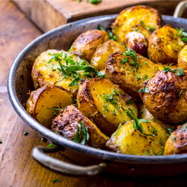 Shallow pan with oven roasted potatoes garnished with parsley