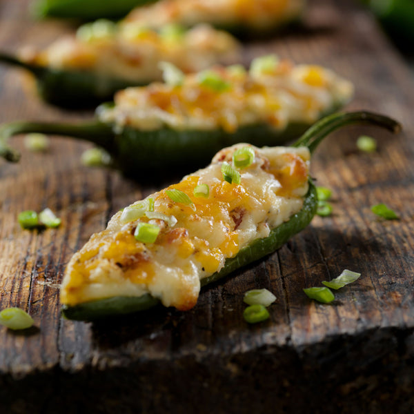 Halved Hatch Chile stuffed with cheese and filling, topped with green onions