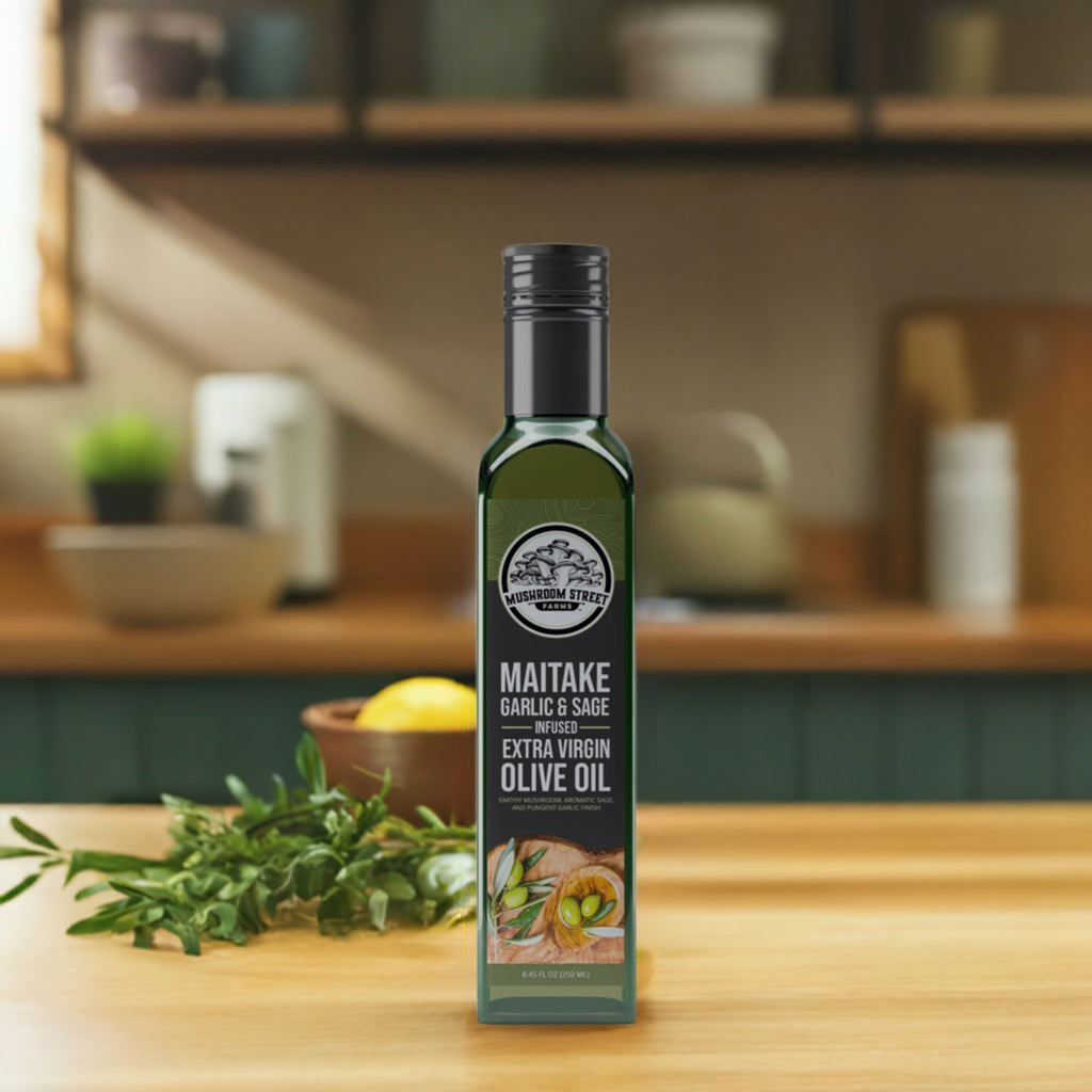 Bottle of maitake, garlic and sage infused olive oil on a wooden kitchen counter with fresh herbs and a lemon